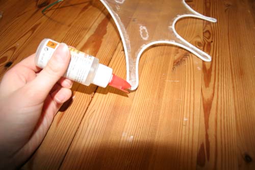 Glue being put on the tip of a small edge out of a bottle